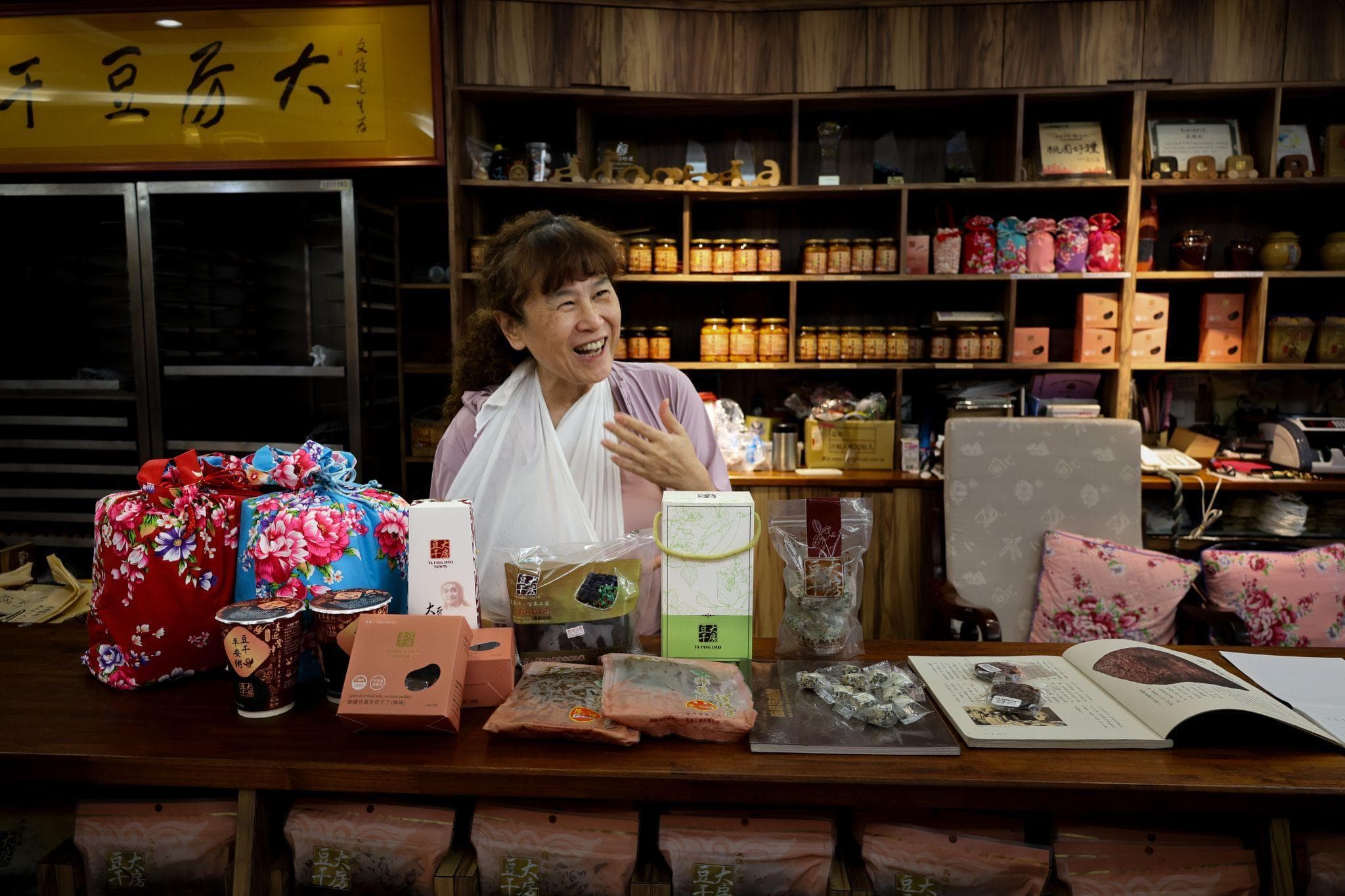 Huang Shu-Yuan laughing while presenting products at her family's tofu shop
